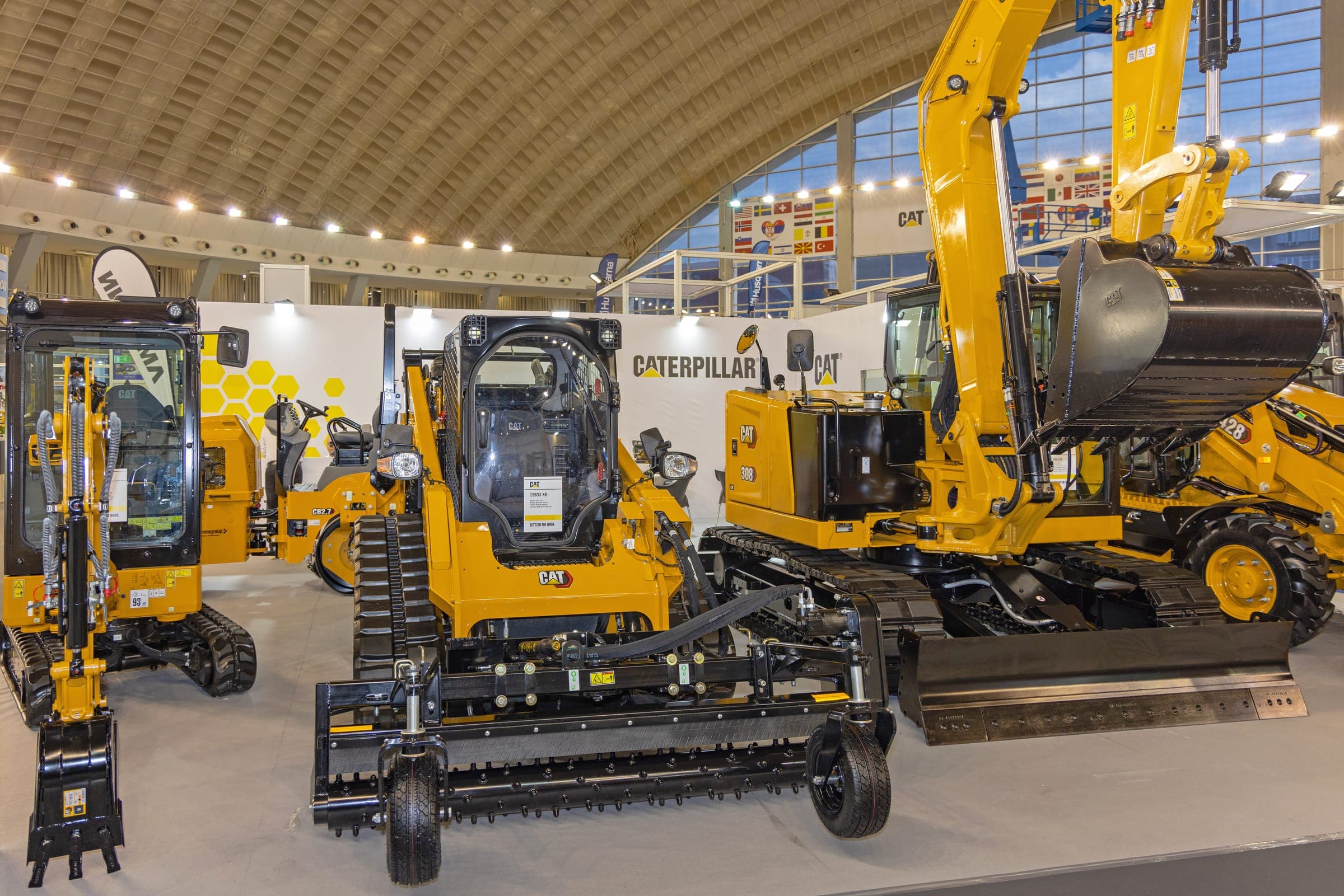 Yellow excavators and loaders in an exhibition hall