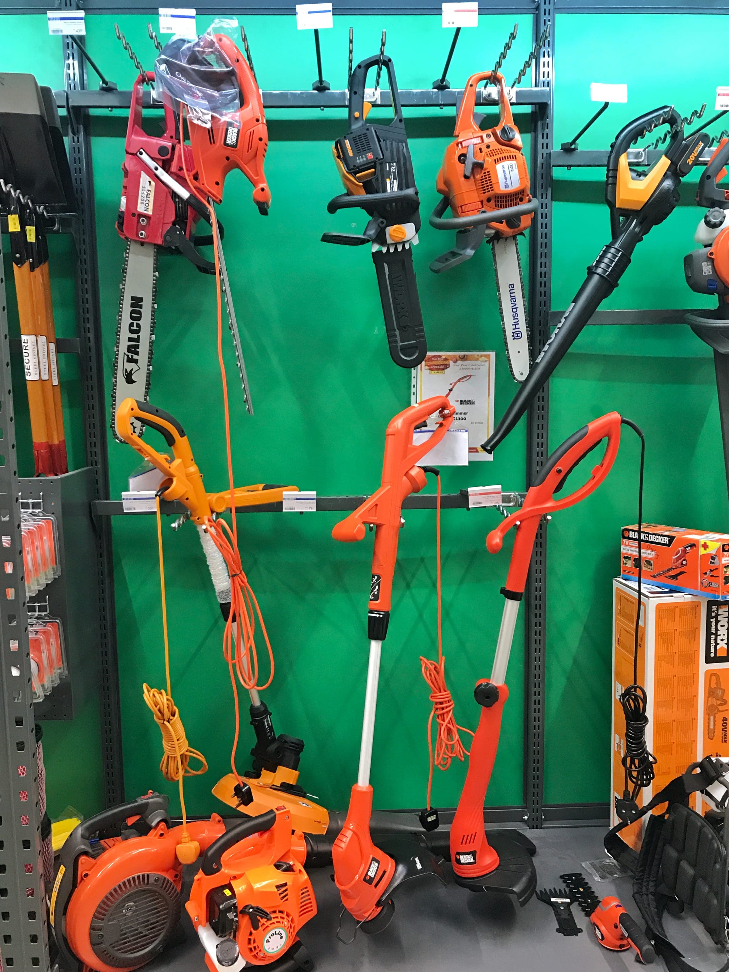 Electric trimmers and a chainsaw on a green display