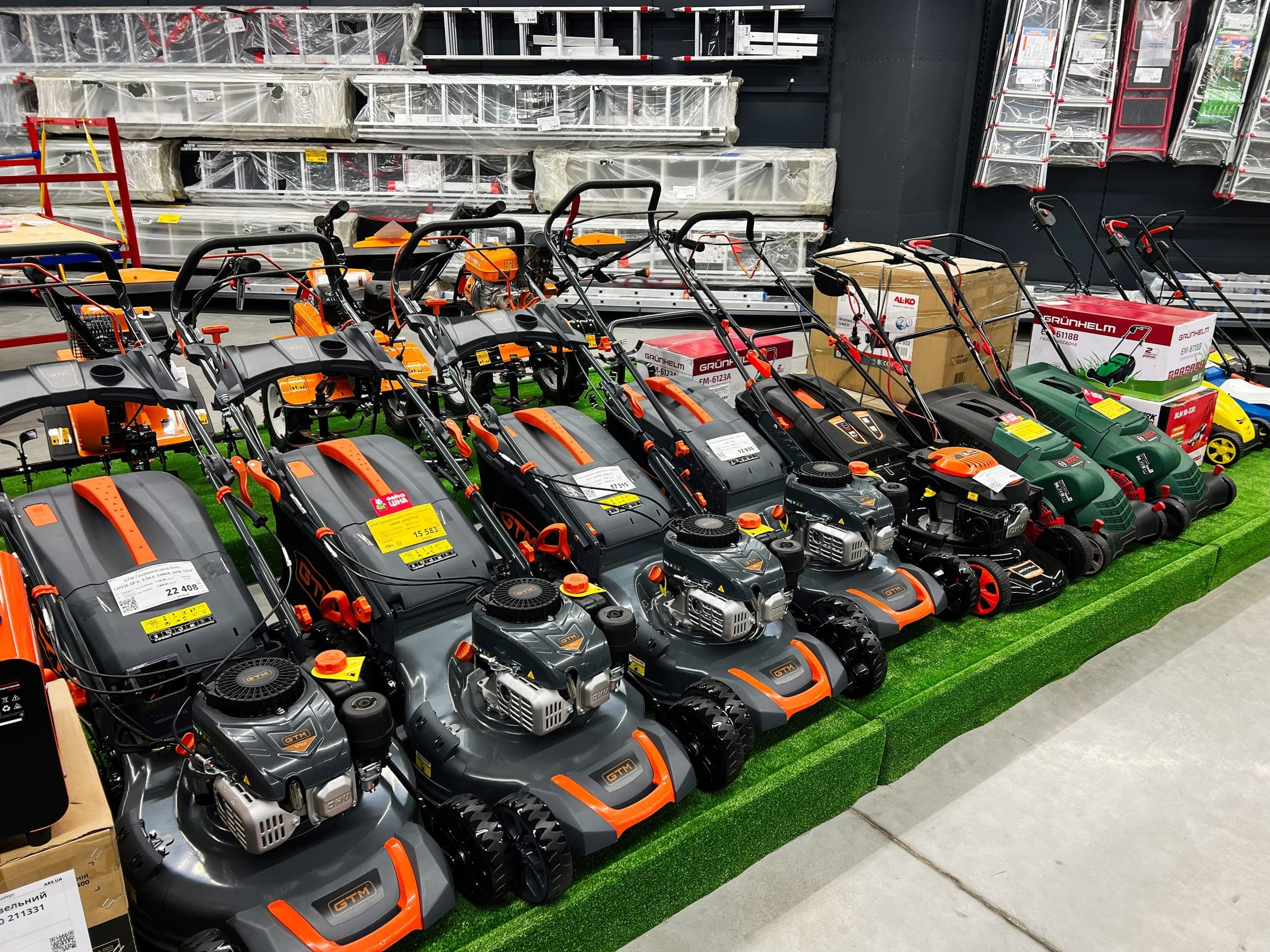 Row of lawn mowers on a display stand